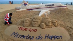 Indian sand artist Patnaik applies final touches to a sand art sculpture he created wishing for the well being of the passengers of Malaysian Airlines flight MH370, on beach in Puri, in the eastern Indian state of Odisha