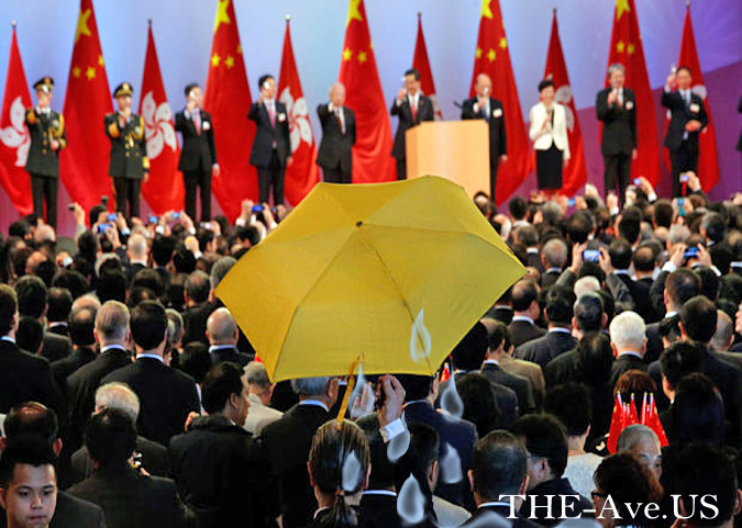 A district councillor, raises a yellow umbrella as Hong Kong Chief Executive Leung Chun-ying (5th R) and other officials raise a toast to at a reception following a flag raising ceremony in Hong Kong  Photo: BOBBY YIP/REUTERS
