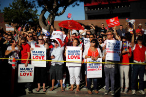 People with banners cheer at a rally in West Hollywood, California after the United States Supreme Court ruled on California's Proposition 8 and the federal Defense of Marriage Act June 26, 2013. The U.S. Supreme Court delivered a landmark victory for gay rights on Wednesday by forcing the federal government to recognize same-sex marriages in states where it is legal and paving the way for it in California, the most populous state. REUTERS/Lucy Nicholson (UNITED STATES - Tags: SOCIETY POLITICS)