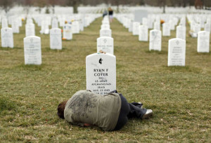 Lesleigh Coyer, 25, of Saginaw, Michigan, lies down in front of the grave of her brother, Ryan Coyer, who served with the U.S. Army in both Iraq and Afghanistan, at Arlington National Cemetery in Virginia March 11, 2013. Coyer died of complications from an injury sustained in Afghanistan.  REUTERS/Kevin Lamarque  (UNITED STATES - Tags: POLITICS CIVIL UNREST OBITUARY) - RTR3EUTW